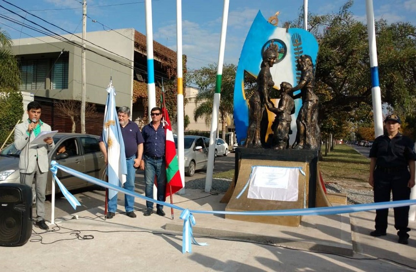 Raúl Taretto y Juan Itcea posan representando a la colectividad vasca junto al monumento a los Inmigrantes en Gral. Rodríguez