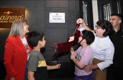 Itziar Aguirre descubre la placa de Cocinera Distinguida en el frente de Trainera, junto a su familia y a la concejala Verónica Irizar