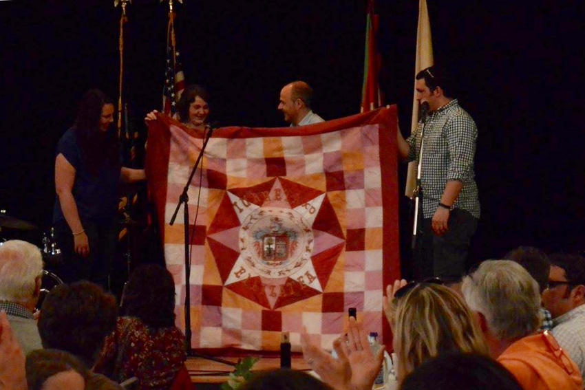 Members of the Oinkari dance group and the mayor of Iurreta (in the center) showing the flag that was especially embroidered for Boise and which will be used by the Boise dancers at their special performances of Dantzari-dantza. 