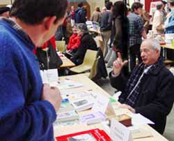 El escritor zuberotarra nacido en París Txomin Peillen charla detrás de su stand en Sara (foto Euskal Kultura)