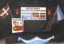 Símbolos y carteles de Villegasko Euskaldunak en un stand del Centro Vasco de General Villegas