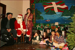 Con Emilia Doyaga al micrófono, Olentzero y Santa Claus repartieron regalos ente los niños y niñas de la euskal etxea neoyorquina (foto eeny)