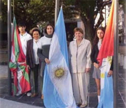 Las responsables del emprendimiento posan junto a los alumnos y alumnas encargados de llevar a cabo la ceremonia. Participar en la misma constituye un premio o reconocimiento escolar a su aplicación, compañerismo o asistencia.