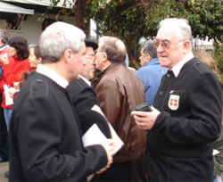 Miembros del Coro con su tradicional vestimenta conversando --a la izquierda, Iñaki Esnal frente a Fernando Zubia--  momentos antes de iniciarse el pasado domingo la misa, solemnizada por sus cantos, del Día de San Valentín Berrio-Otxoa