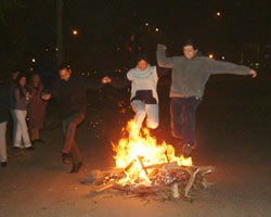 Miembros y simpatizantes de Haize Hegoa saltan sobre el fuego en la hoguera de San Juan organizada por esta euskal etxea montevideana