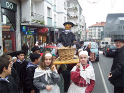 Chicos y chicas de una escuela portan la figura de un Olentzero por las calles de una localidad vasca