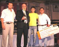 El joven galardonado, vestido de amarillo, en el momento de recibir el premio 'Saladillo de Oro' 2005 y el trofeo y cheque-regalo que lo acompañan