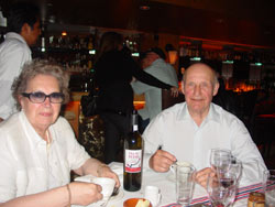 Dos comensales posan en el Piperade frente a una botella de txakoli tinto Talai Berri sobre un mantel tradicional de estilo vasco (foto euskalkultura.com)