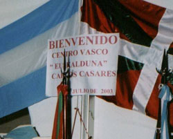 Cartel y señal del Centro Vasco 'Euskalduna' de la ciudad bonaerense de Carlos Casares escoltado por las banderas argentina y vasca