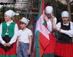 Las dantzaris txikis acompañando o portando la ikurriña durante el acto de homenaje del sábado