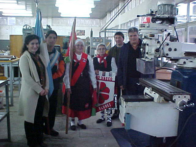 Graciana Goicoechandia, presidenta del CV de Las Flores (izquierda), César Arrondo (derecha), y entre ellos abanderados de 'Loretako Euskaldunak' y representante de la Escuela Técnica Nº1, junto a la máquina fresadora