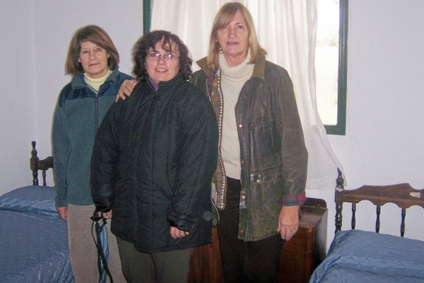 La presidenta del CV Itxaropen, Silvina Bordenave, acompañada por directivos del Hogar de Ancianos, junto a dos camas con colchas elaboradas con la tela donada (foto ABC-Saladillo)