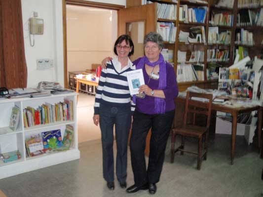 Ma. Esther Arrondo (drcha), responsable de la biblioteca Eusko Txokoa, entregó a Nerea Grassi un ejemplar del último número de 'Guregandik' en la reunión de bibliotecas realizada durante la Semana Vasca (foto EuskalKultura.com)