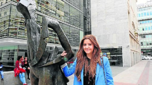 Ainhoa Barrenetxea posa en Bilbao con la escultura de "El Paseante", junto a la Biblioteca de la Diputación Foral de Bizkaia (foto Jose Sampedro-Deia)