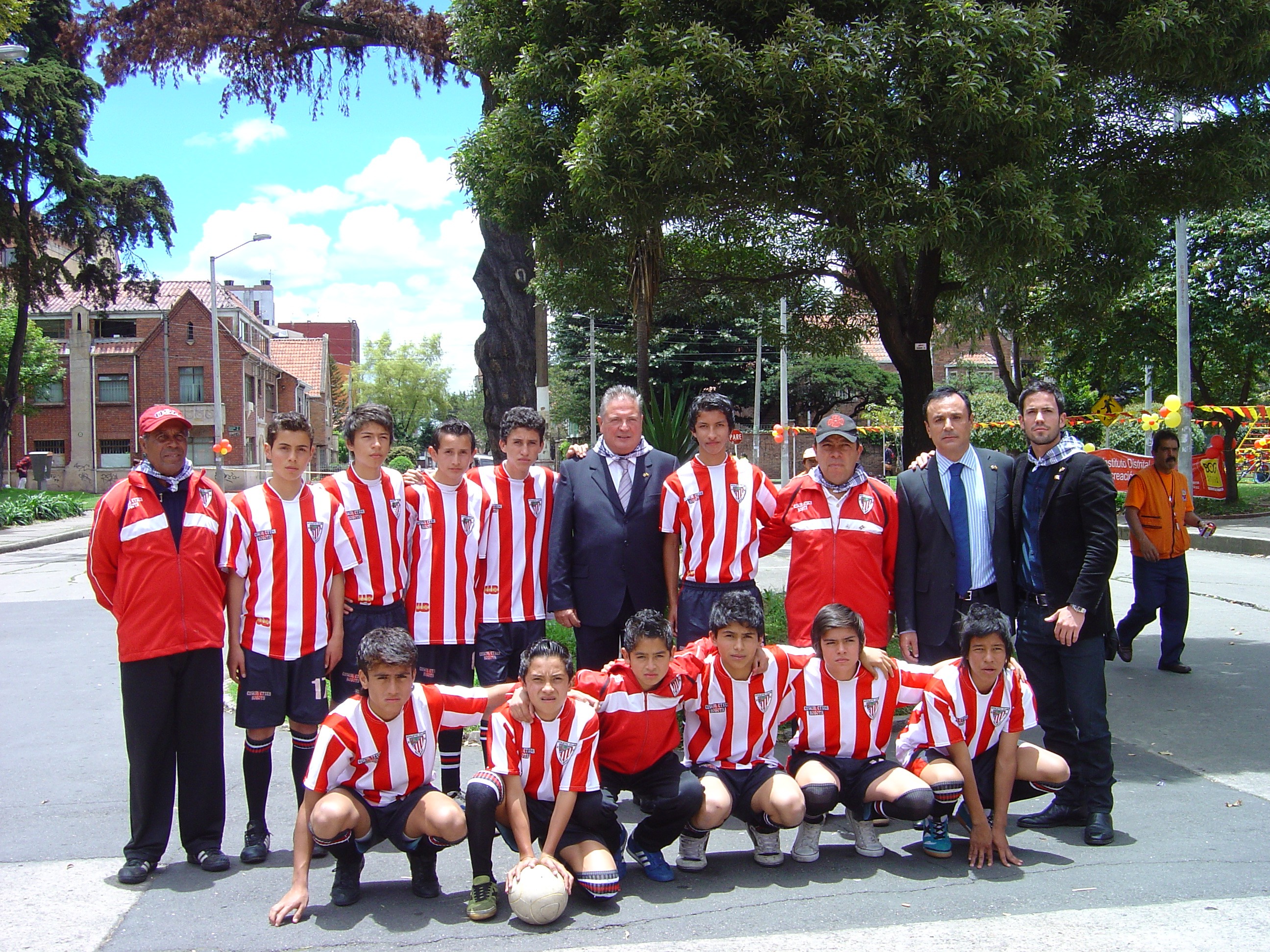 Julián Celaya, Director para los Ciudadanos y las Colectividades (centro) y otros representantes institucionales junto a los chicos del Athletic Juvenil de Euskal Etxea, que participaron en la inauguración jugando un partido de fútbol (fotos Irekia)