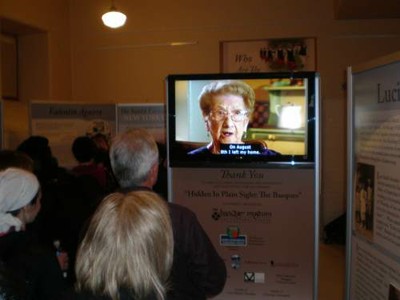 New Yorken, Lucy Garateari eginiko bideo elkarrizketak ematen zien ongi etorria bisitariei 'Hidden in plain sight: The Basques" erakusketan Ellis Island-en; gauza bera egiten du gaur egun Boisen (argazkia EuskalKultura.com)