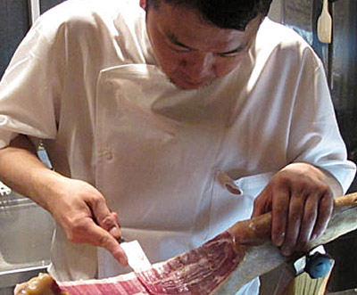 Naoki Wada, cocinero del Abasque, cortando jamón, suponemos que de Baiona, es un suponer (foto R.Swinnerton)