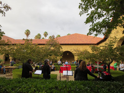 Las cantantes de Noka y el guitarrista Laurent Ascarain, de espaldas, frente al público reunido en los jardines de la Universidad de Stanford (foto ILLuzuriaga)