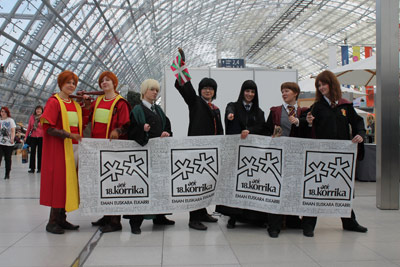 Otakus korrikazales en la Feria del Libro de Leipzig, entre ellos un euskaltzale Harry Potter tras la pancarta de la Korrika sosteniendo una ikurriña(foto ULauzirika)