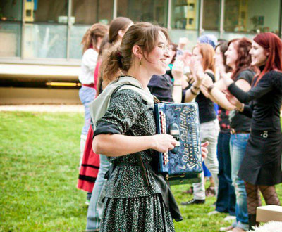 La lectora Izaskun Pérez tocando el acordeón en la Semana Vasca de 2011 de Szeged; detrás, sus alumnos bailando la Esku-Dantza