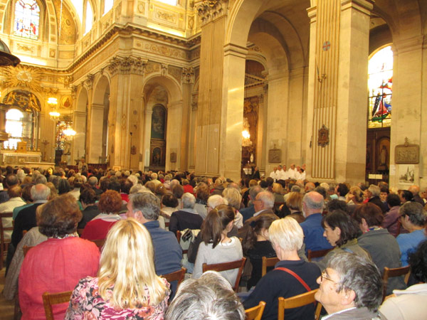 Pariseko Saint Louis eliza jendez lepo, Ibaeta Abesbatzaren emanaldia noiz hasiko zain. Eskuinean, elizaren albo batean ageri dira abesbatzako kideak, zuriz (argazkia Ibaeta Abesbatza)