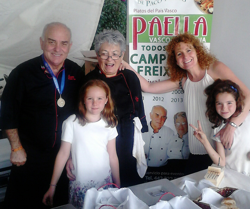 Paco Casteig y Bego Illarramendi acompañados de una amiga, Eva, y sus hijas Carlota y Natalia, frente a un cartel de su restaurante