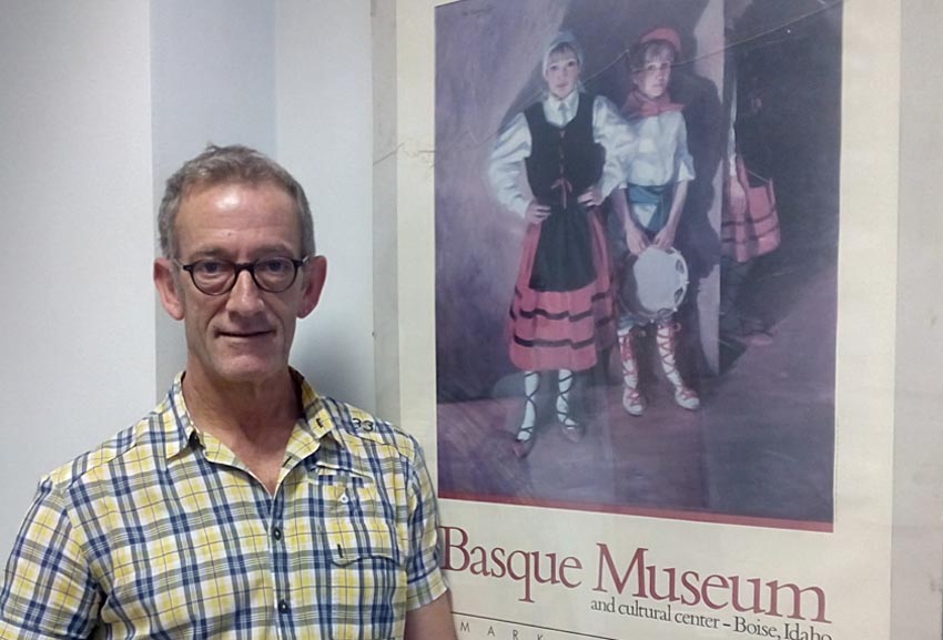 Kinku Zinkunegi, coordinator of the Euskara Munduan Program for HABE along with a poster at the Boise Basque Museum (photoEuskalKultura.com)