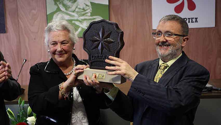 La  bibliotecaria y escritora Arantzazu Amezaga sostiene el premio junto a Koldo Viñuales, de Irujo Etxea (foto Noticias de Navarra)