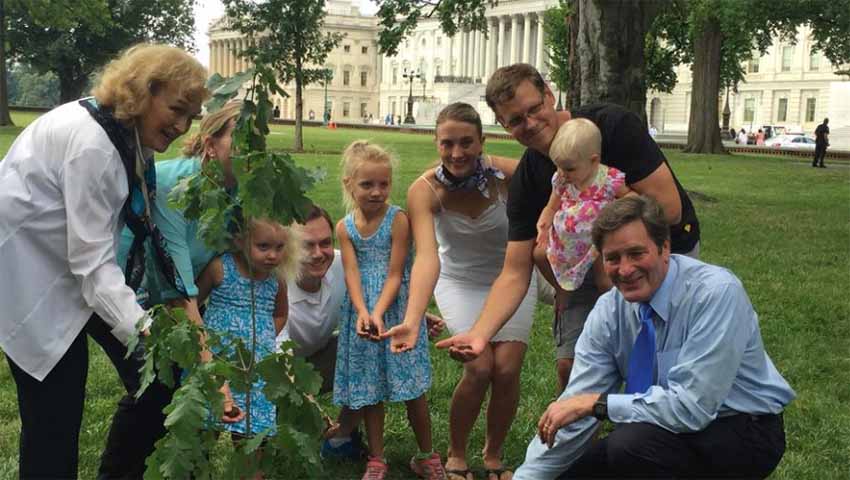 Rep. John Garamendi (bottom right) and his family cover the roots of an oak tree on Capitol Hill. The sapling is a descendant of a historic tree in the Basque Country. (Sarah D. Wire/ Los Angeles Times)