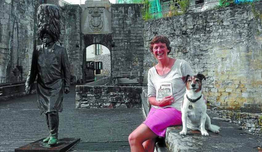 Alex Hallatt posa contenta con su libro y con su perro 'Billie' junto a la escultura del hachero (foto Edu MendibilDV)