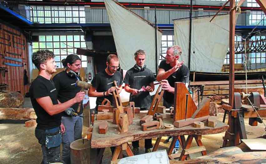 Cuatro de los estudiantes de la escuela de carpintería de ribera atienden las explicaciones de su profesor, Brian McClellan, en el denominado Teatro del Mar, donde se construyen embarcaciones tradicionales (foto Mikel Fraile-DV)