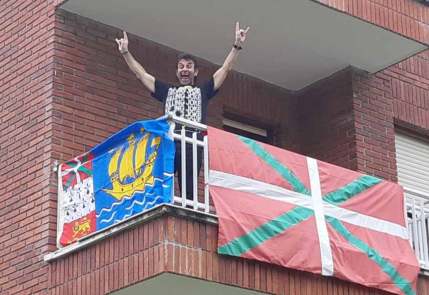 Diasporako euskalduna, Vancouverreko Johnny Ugalde ondarroar australiarrak 'Gora Euskadi' diosku Sukarrietako bere etxeko balkoitik, ikurrinarekin batera St Pierre eta Miquelongo bandera balkoiean