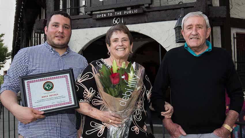 Miren Artiach tras recibir en 2018 el "Legacy Award" de Euzkaldunak, junto al presidente Tyler Smith y su marido Jose Mari