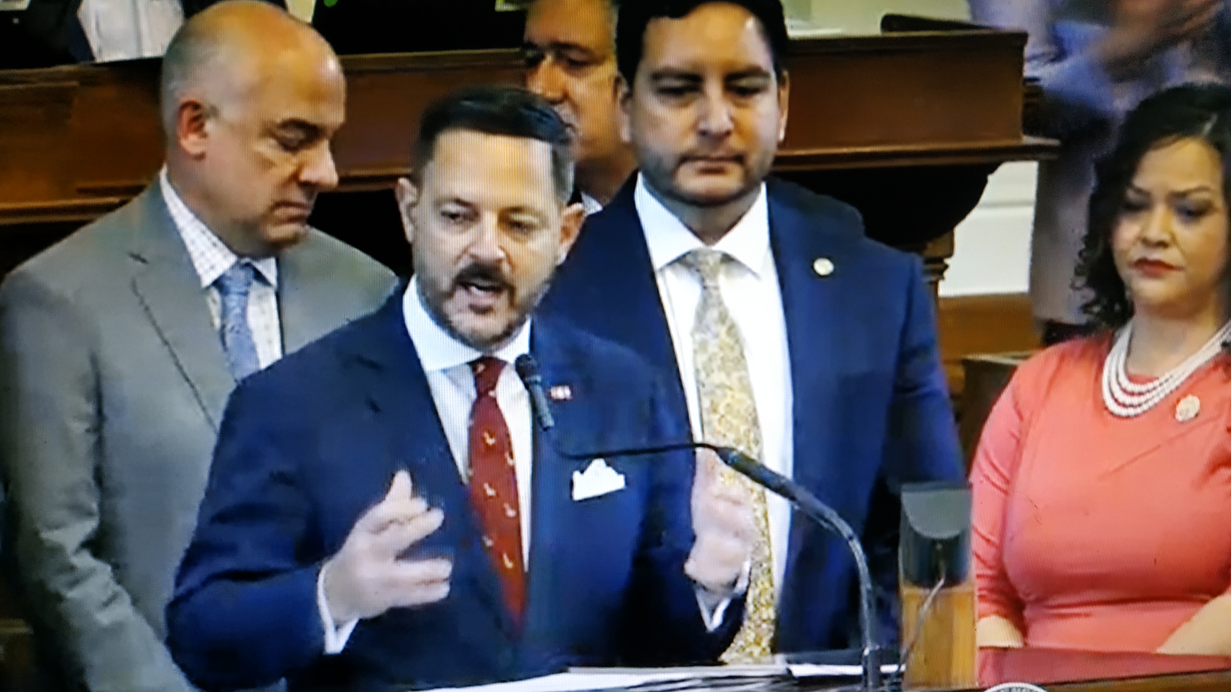 El congresista estatal Rafael Anchía se dirige a la Cámara flanqueado por representantes demócratas y republicanos, que apoyaron a una la Resolución (foto THR TV)