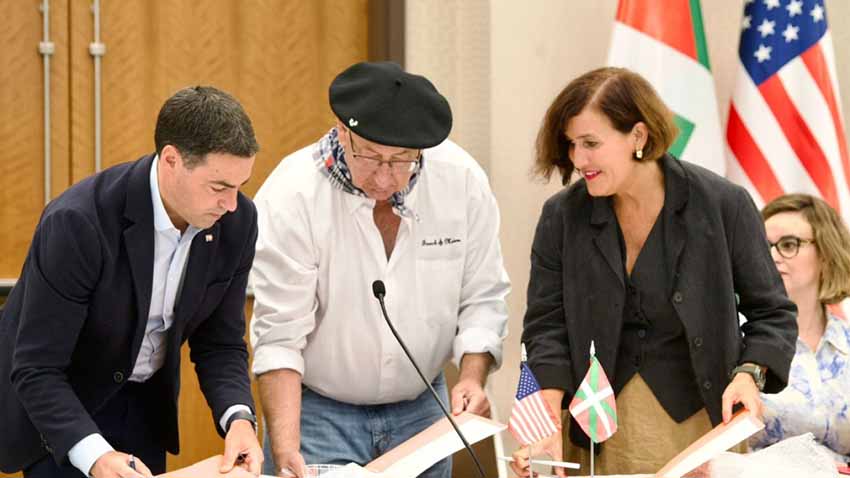 El lehendakari Pradales, Jean Flesher presidente de NABO y la directora del Instituto Vasco Etxepare, Irene Larraza, firmando un acuerdo el pasado agosto en Boise en el transcurso de Jaialdi